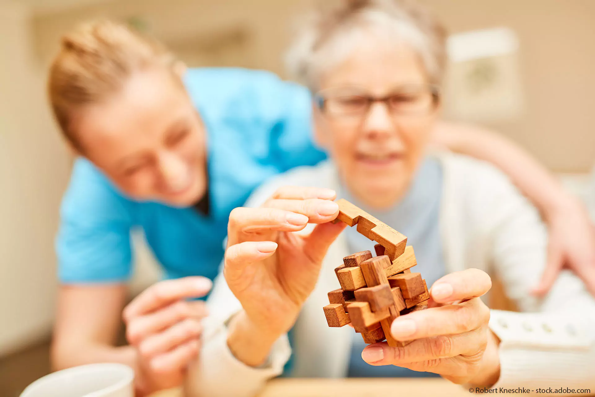 Praxis für Ergotherapie Boettcher in Greifswald - Behandlungsbereich - Hirnleistungstraining- Ältere Frau mit Therapeuting- Holzspielzeug als Therapiemittel im Fokus